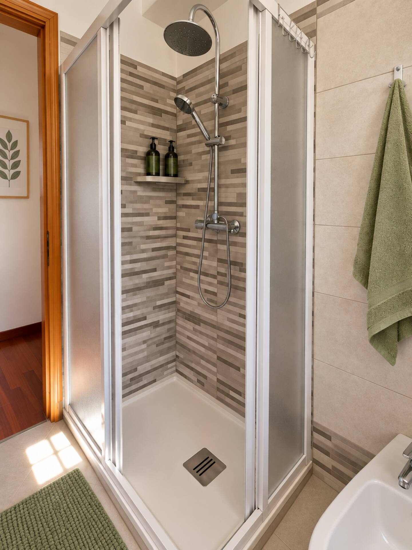 The dual-head shower with mosaic tiles, in the apartment