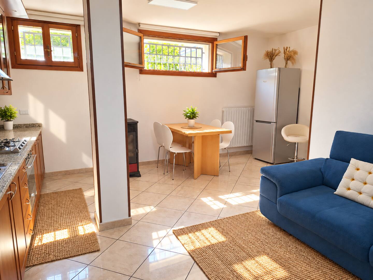 The bright open-plan space of the apartment, with blue sofa and dining area