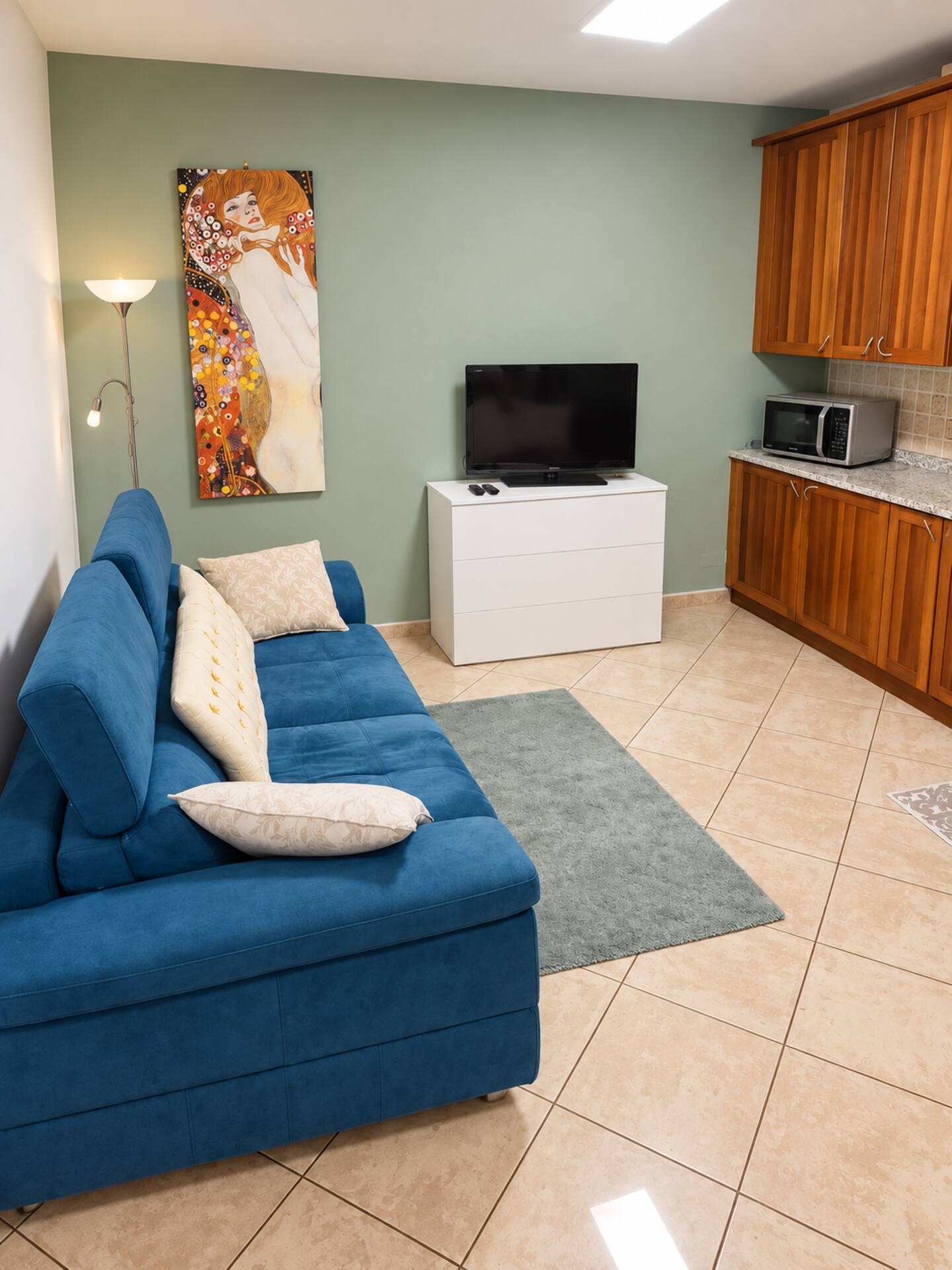 The apartment lounge with blue sofa and green wall