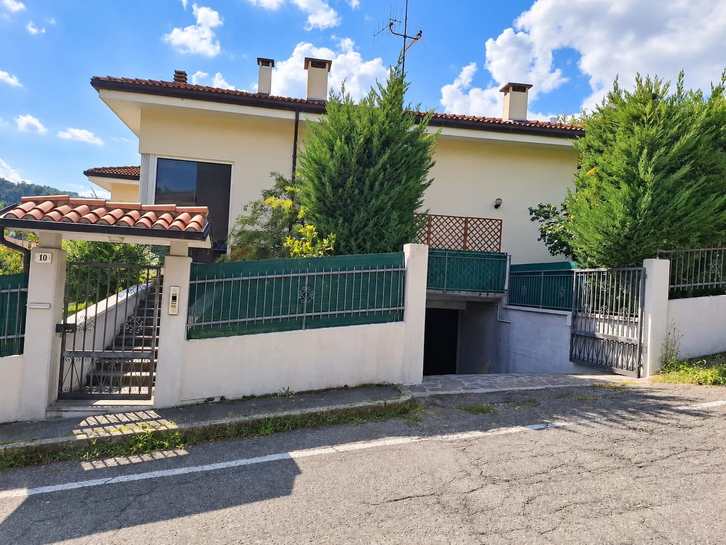 The house seen from the road, with the pedestrian gate and garage entrance