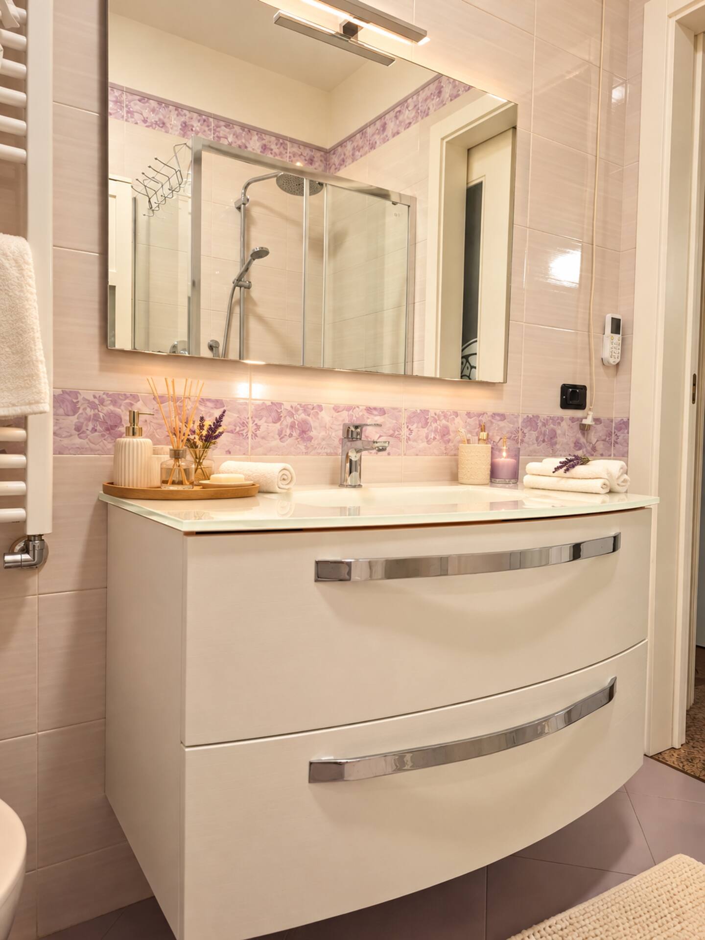 The upper-floor bathroom with white vanity unit and lit mirror