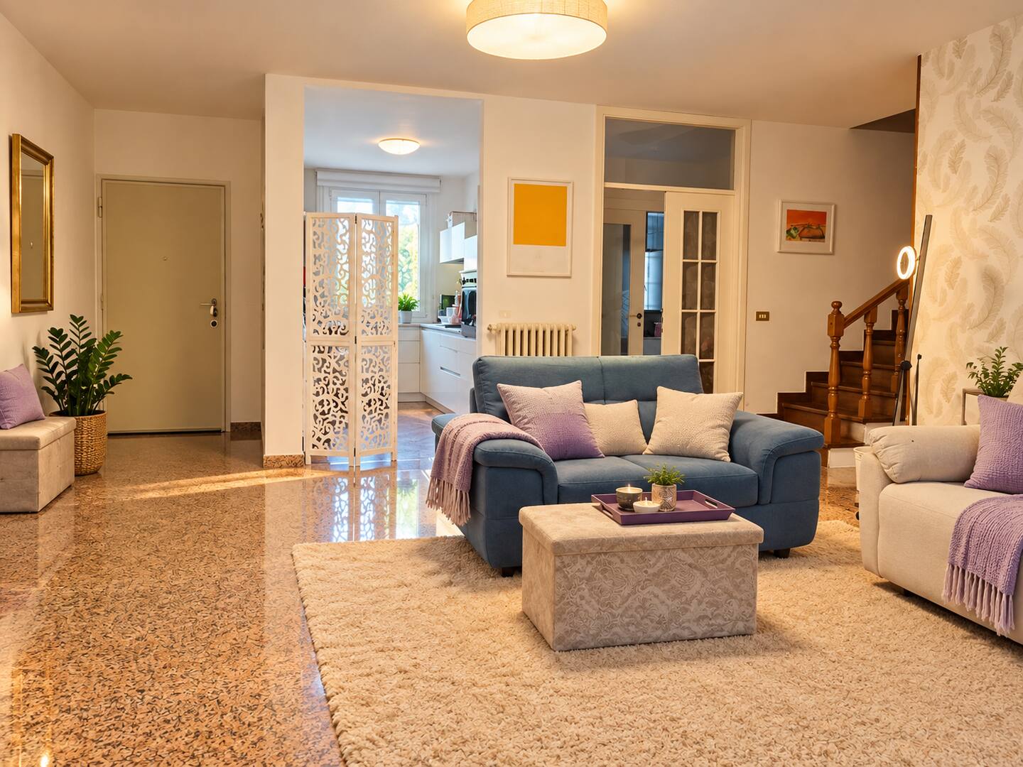 The living room with blue sofa, pouf and rug