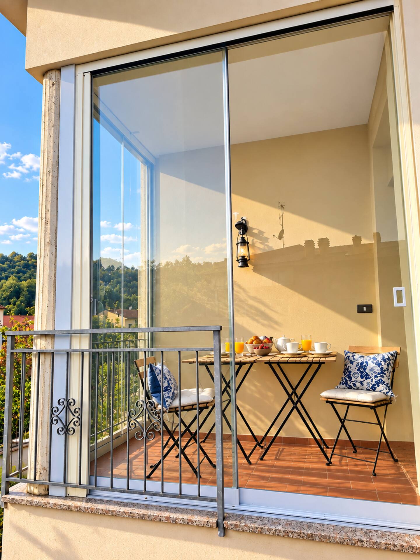 The glazed veranda of B&B Tre Manici di Scopa at sunset, with the table laid and the Bolognese hills
