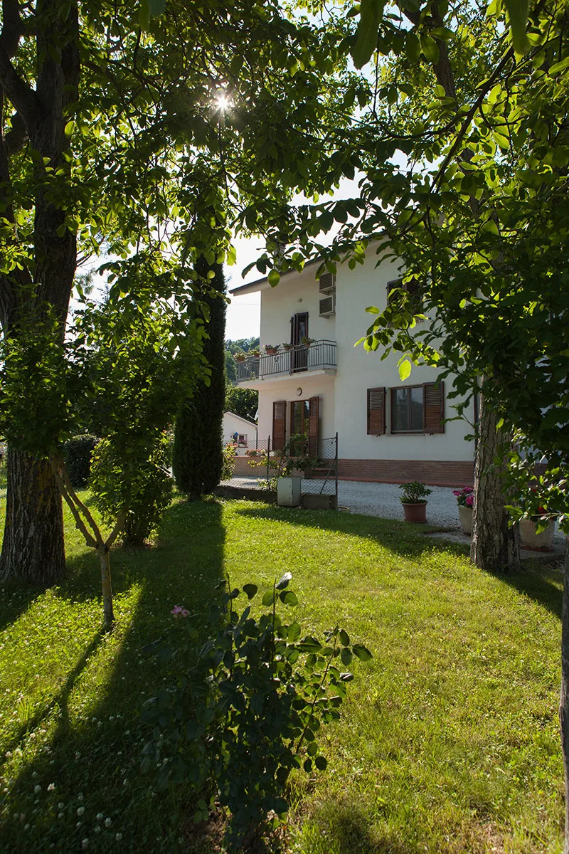 La casa del B&B Tre Manici di Scopa immersa nel verde delle colline di Urbania, vista dal giardino